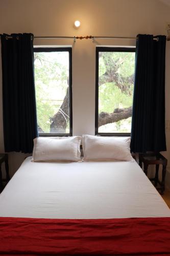 a bedroom with a large bed with two windows at Desert Nights in Mandāwa