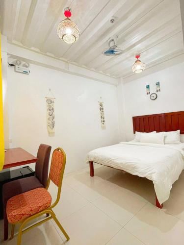 a bedroom with a bed and a desk and a chair at Moalboal Seaside Resort in Moalboal