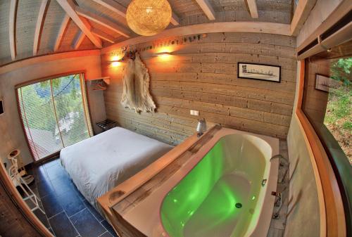 a bathroom with a tub and a bed in a room at Entre les Arbres in Saint-Jean-d'Aulps