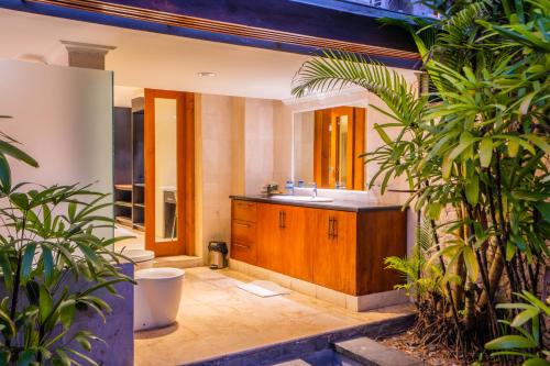 a bathroom with a sink and a mirror at Hening Jimbaran in Jimbaran