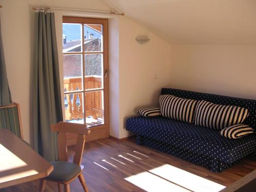 ein Wohnzimmer mit Sofa und Fenster in der Unterkunft Honsahof in Strassen