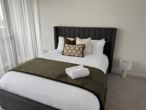 a bedroom with a large bed with a black headboard at Contemporary 2BR Stay in Campbell