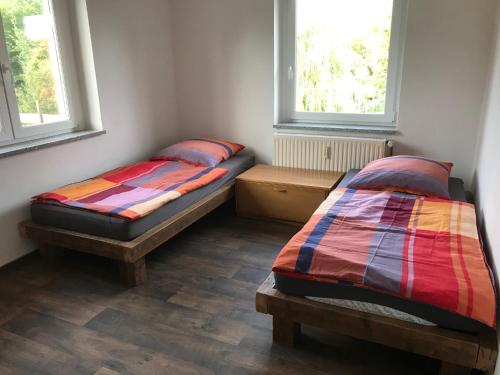 two beds in a room with two windows at Wohnung Regina in Wildenfels