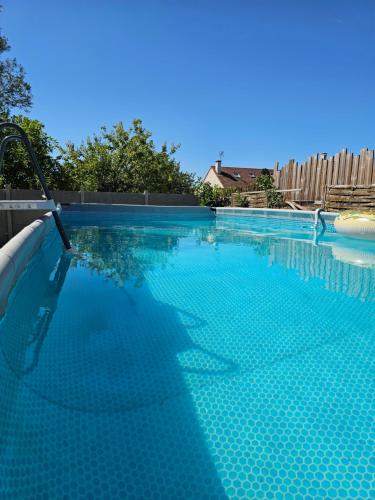 a large swimming pool with blue water at Appartement T2 confortable - ParisGetAway95 in Pierrelaye