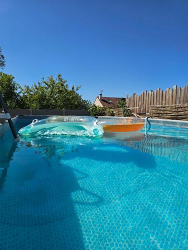 a swimming pool with two boats in the water at Appartement T2 confortable - ParisGetAway95 in Pierrelaye
