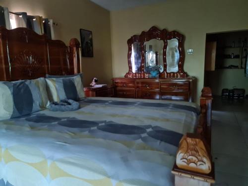 a bedroom with a large bed and a large mirror at Round Hill View Heights in Pedro Cross