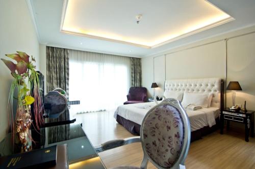 a bedroom with a bed and a desk with a chair at CT Suite in Pattaya South