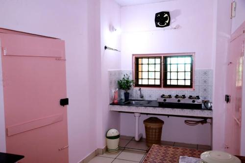 a bathroom with a sink and a window at Alleppey La Casa in Alleppey