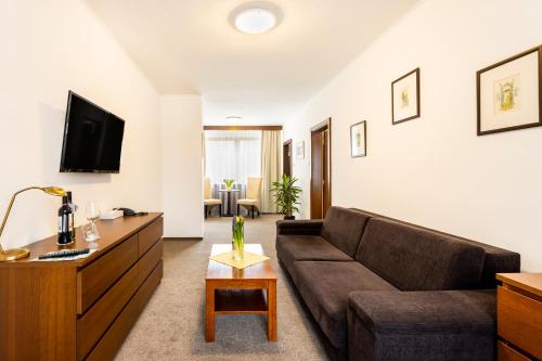 ein Wohnzimmer mit Sofa und Tisch in der Unterkunft Hotel Park in Piešťany