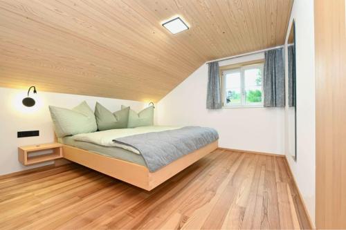 a bedroom with a bed with a wooden ceiling at GebirgsImker-Apartment in Egg