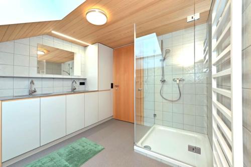 a bathroom with a shower and a glass shower stall at GebirgsImker-Apartment in Egg