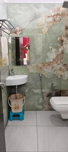 a bathroom with a sink and a toilet and a mirror at Hotel Royal Orbit in Rajauli