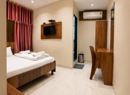 a hotel room with a bed and a television at Hotel Volga 2 in Mumbai