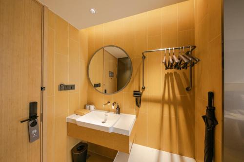a bathroom with a sink and a mirror and a shower at JI Hotel Beijing Guanganmen in Beijing