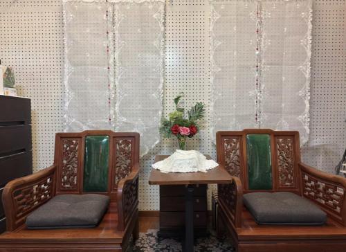 two chairs and a table with a vase of flowers at 美々パレスー沖縄の伝統文化に出会う琉球モダンな隠れ家ー in Itoman