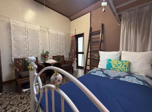 a bedroom with a bed with a blue comforter at 美々パレスー沖縄の伝統文化に出会う琉球モダンな隠れ家ー in Itoman