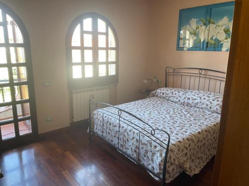 a bedroom with a bed and two windows at Sweet home Torre del lago in Torre del Lago Puccini