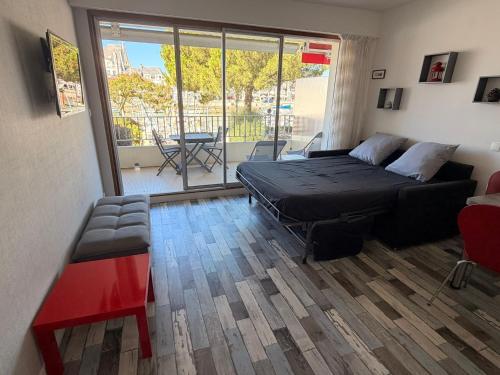 a bedroom with a bed and a couch and a balcony at Ar Kevel in La Baule