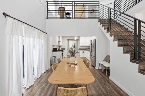 a dining room with a wooden table and a staircase at Casa Playa Long Beach in Long Beach