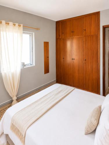 a bedroom with a large white bed with a wooden cabinet at Margianna Apartments1 in Káto Ássos