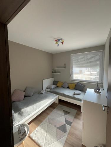 a bedroom with two beds and a window at Panorama Apartman Zamardi in Zamárdi