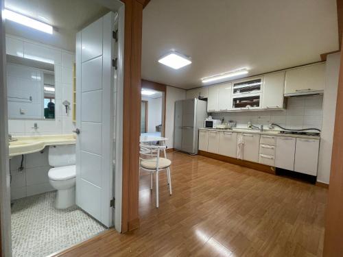 a large kitchen with a sink and a refrigerator at BV House in Incheon