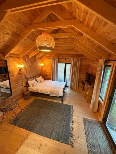 a bedroom with a bed in a wooden room at Casa Gorjeana Complex Agroturistic in Peştişani