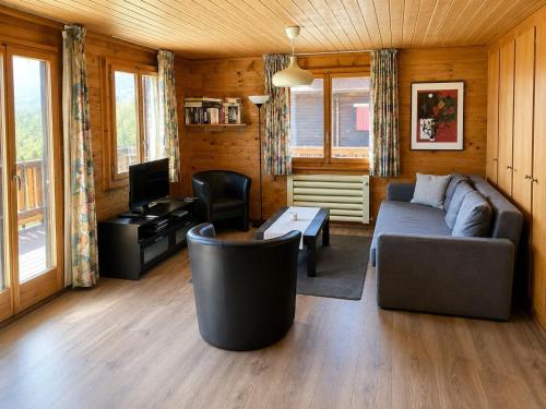 a living room with a couch and a tv at Chalet in Wiler near Ski Lift & Views in Fiesch