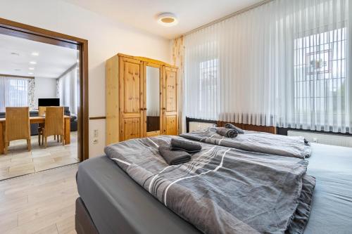 two beds in a bedroom with a dining room at Ferienwohnung Ostermann in Plettenberg