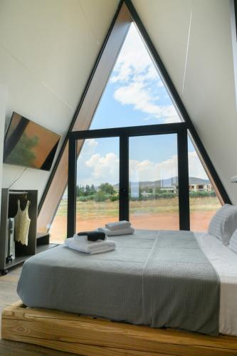 a bed in a room with a large window at Trilogy Resorts in Alexandroupoli