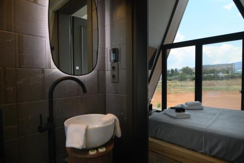 a bathroom with a sink and a mirror and a bed at Trilogy Resorts in Alexandroupoli