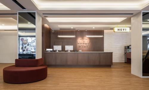 a lobby with a reception desk and a red stool at 休日行旅 Vacay Stay in Tainan