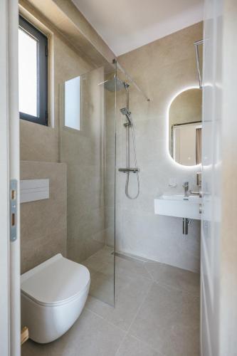a bathroom with a shower and a toilet and a sink at Majestic Bay in Čanj