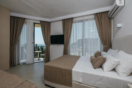 a bedroom with a large bed with a large window at Majestic Bay in Čanj