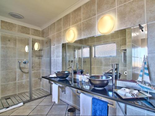 a bathroom with two sinks and a shower at Dunestone Boutique GuestHouse in Langebaan