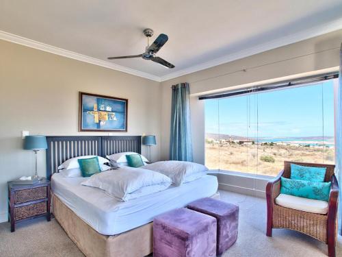 a bedroom with a large bed and a large window at Dunestone Boutique GuestHouse in Langebaan