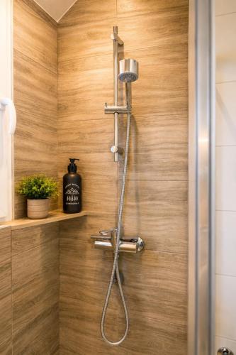 a shower in a bathroom with a wooden wall at Aktivurlaub im Schwarzwald Natur Sport und Erholung in Efringen-Kirchen