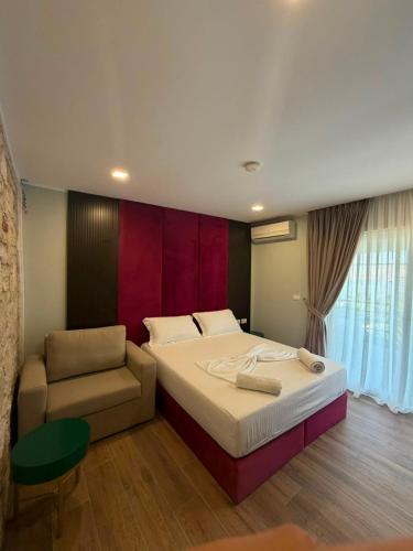 a bedroom with a large bed and a chair at Monarch Beach in Borsh