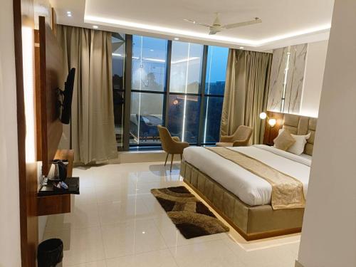 a hotel room with a bed and a large window at HOTEL LAWANG SIGNAGE in Deoghar