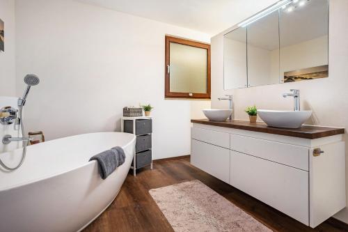a bathroom with two sinks and a tub at Ferienglück Vogelsang in Loßburg