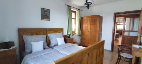 a bedroom with a wooden bed with white pillows at Felföldi Tanyavendégház in Kiskunmajsa