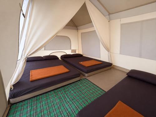 a small room with two beds in a tent at corak alam glamping in Tangkubanperahu