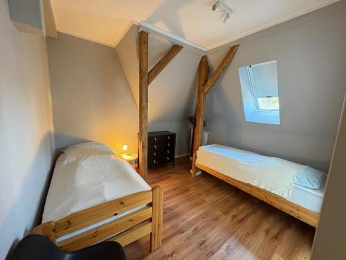 two beds in a room with wooden floors at Seehaus Plön in Plön