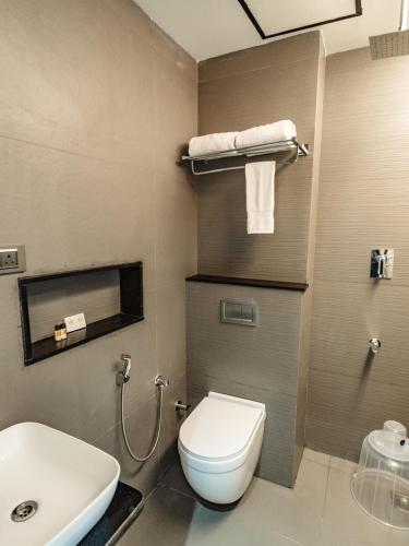a bathroom with a white toilet and a sink at Crown Residency in Kanyakumari
