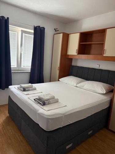 a large bed in a room with blue curtains at Apartment Ćule in Senj