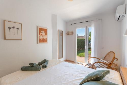 a white room with a bed and a window at Villas 19 Estrellas in Cala en Bosc