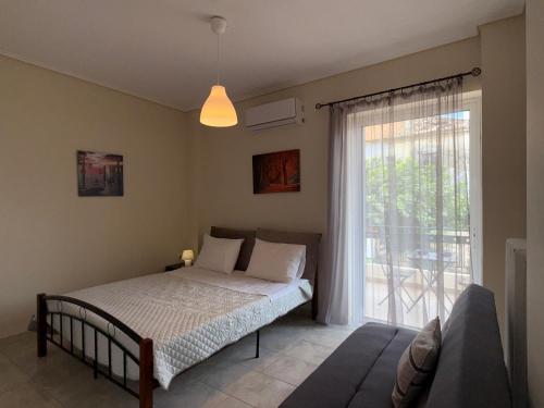 a bedroom with a bed and a large window at Alasrooms A1 in Missolonghi