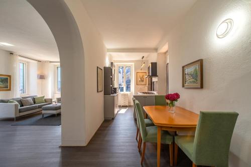 a dining room and living room with a table and chairs at Simo House Stunning Lake View Balcony AC in Carate Urio