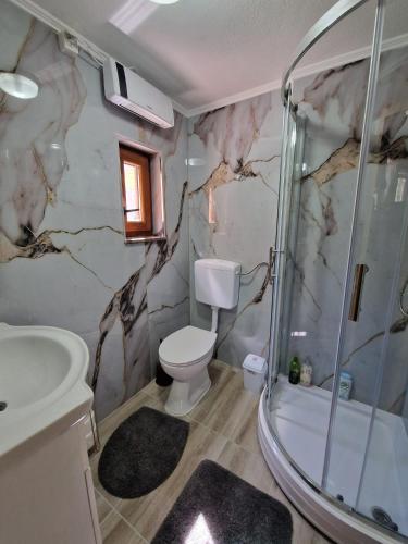 a bathroom with a shower and a toilet and a sink at Apartment Blidinje, Ranch Mikulic in Blidinje