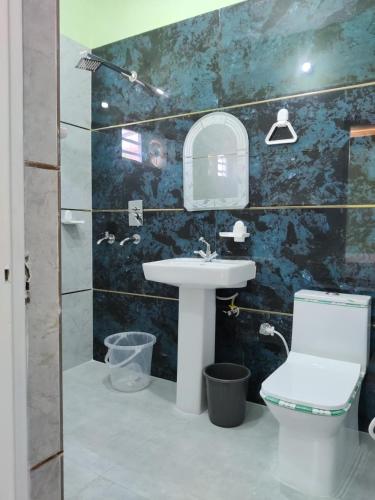 a bathroom with a sink and a toilet at M2 lambardaar in Dehradun